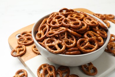 Photo of Tasty pretzel crackers on white table, closeup