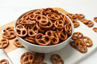 Photo of Tasty pretzel crackers on white table, closeup