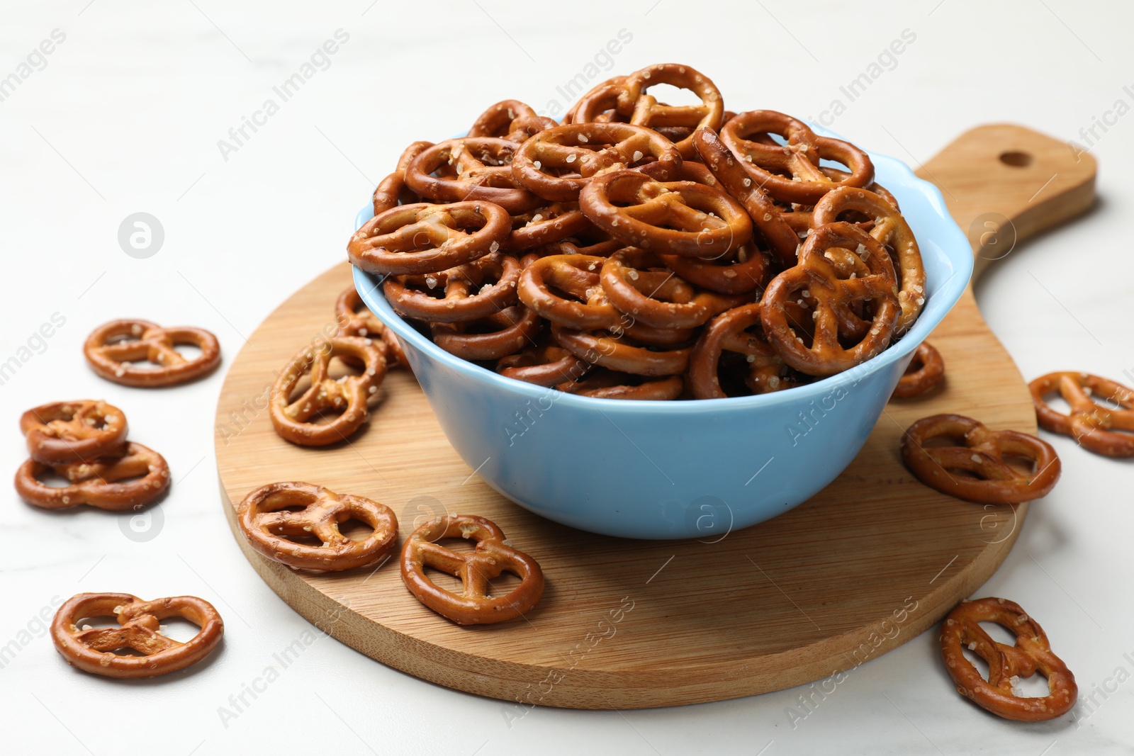 Photo of Tasty pretzel crackers on white table, closeup