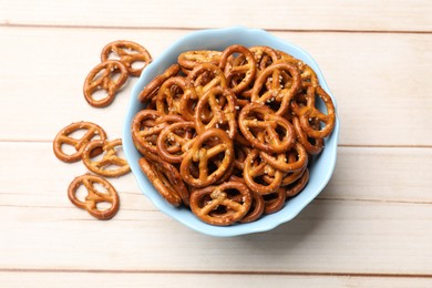 Photo of Tasty pretzel crackers on light wooden table, top view