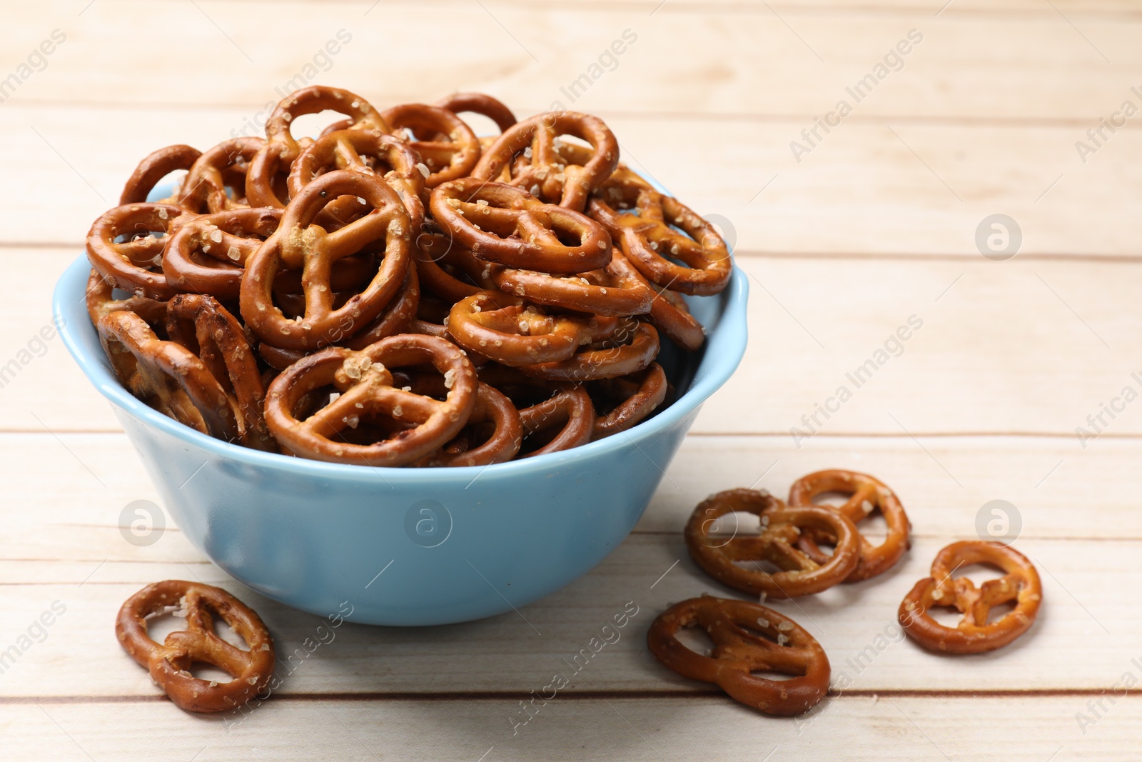 Photo of Tasty pretzel crackers on light wooden table, closeup