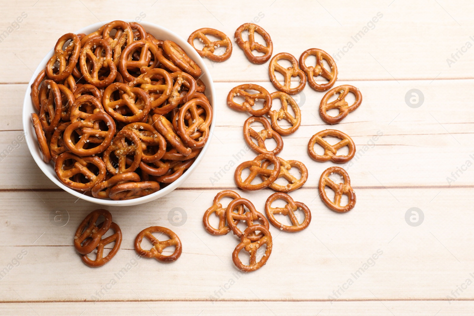 Photo of Tasty pretzel crackers on light wooden table, top view