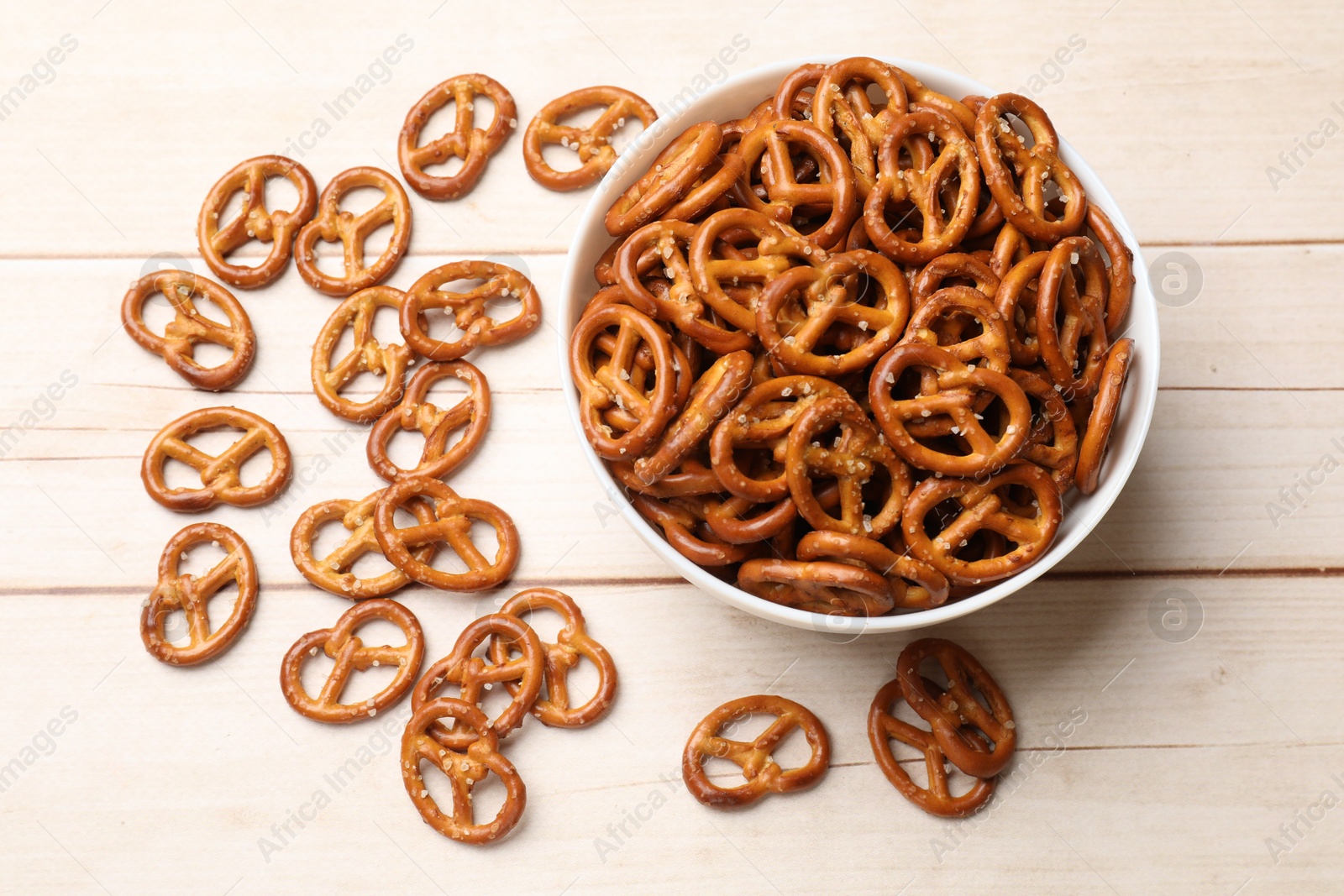 Photo of Tasty pretzel crackers on light wooden table, top view