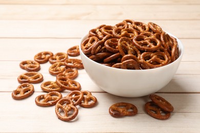 Photo of Tasty pretzel crackers on light wooden table, closeup