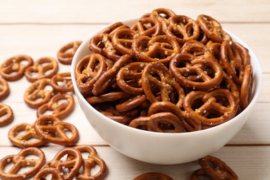 Photo of Tasty pretzel crackers on light wooden table, closeup