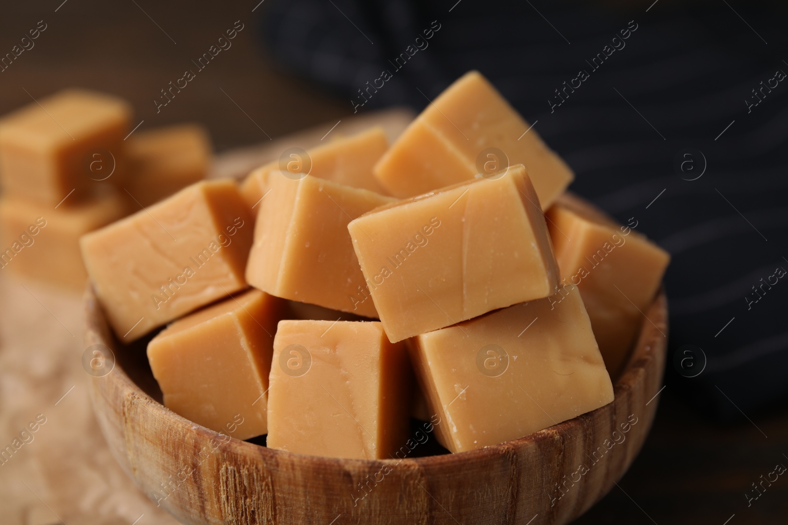 Photo of Tasty sweet caramel candies in bowl on table, closeup