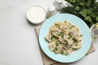 Photo of Delicious pelmeni with green onion served on white table, flat lay