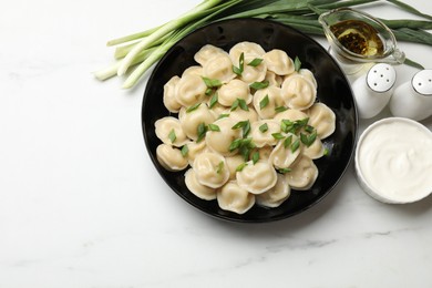 Photo of Delicious pelmeni with green onion served on light table, flat lay. Space for text