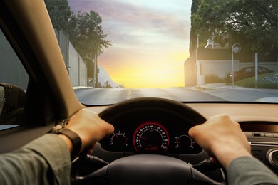 Image of Man driving car in city on sunny morning, first-person view