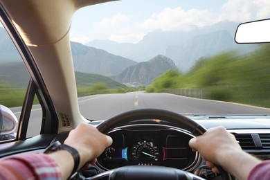 Image of Man driving car on mountain road at high speed, first-person view. Motion blur effect