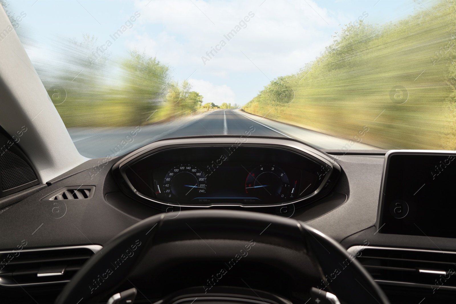 Image of Car driving on empty road at high speed, view from driver's seat. Motion blur effect