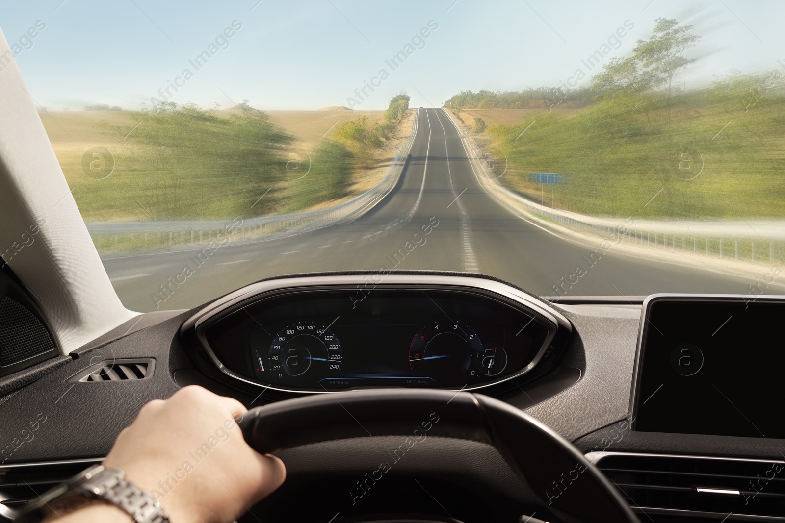 Image of Man driving car on empty at high speed, first-person view. Motion blur effect