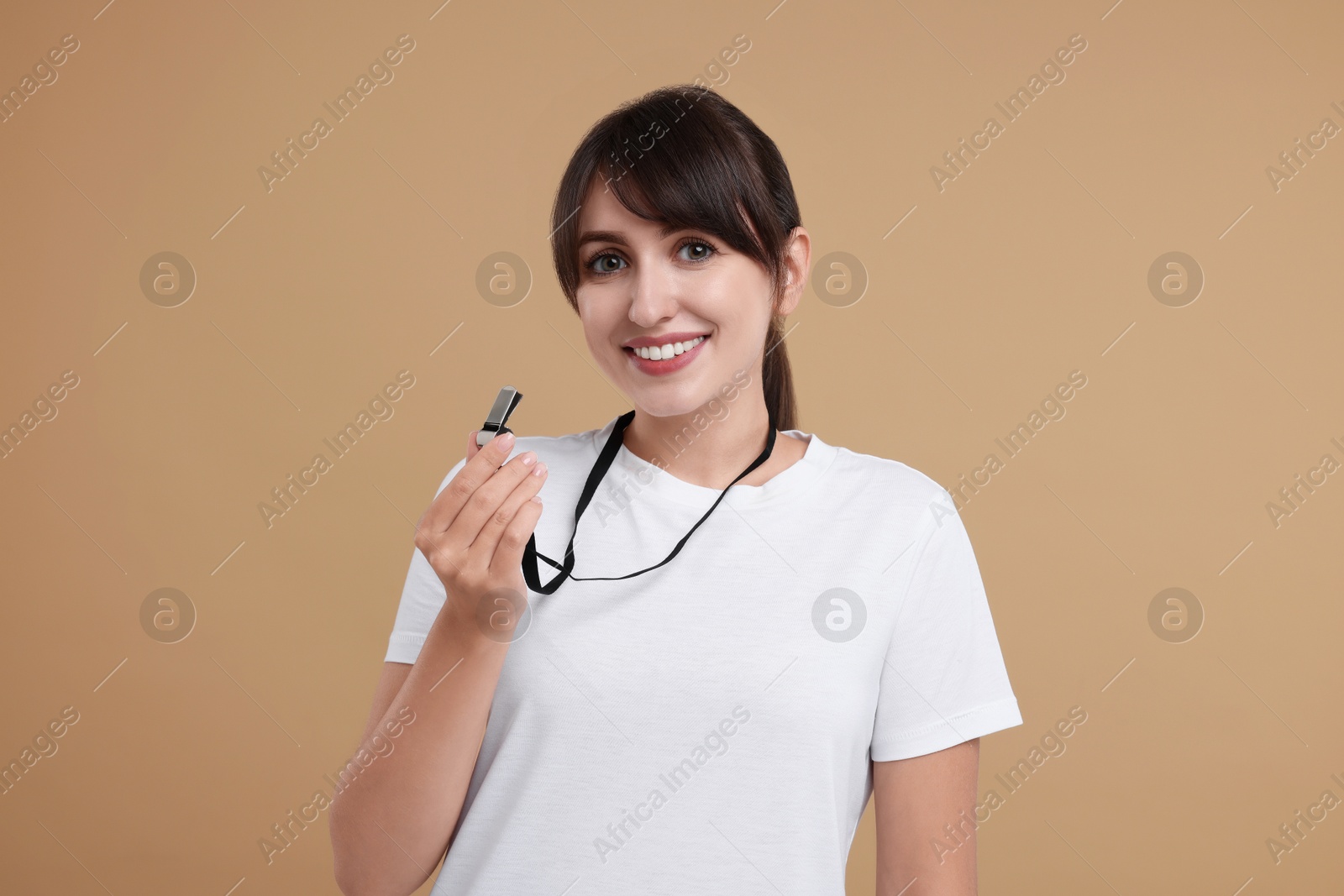 Photo of Happy woman with whistle on beige background