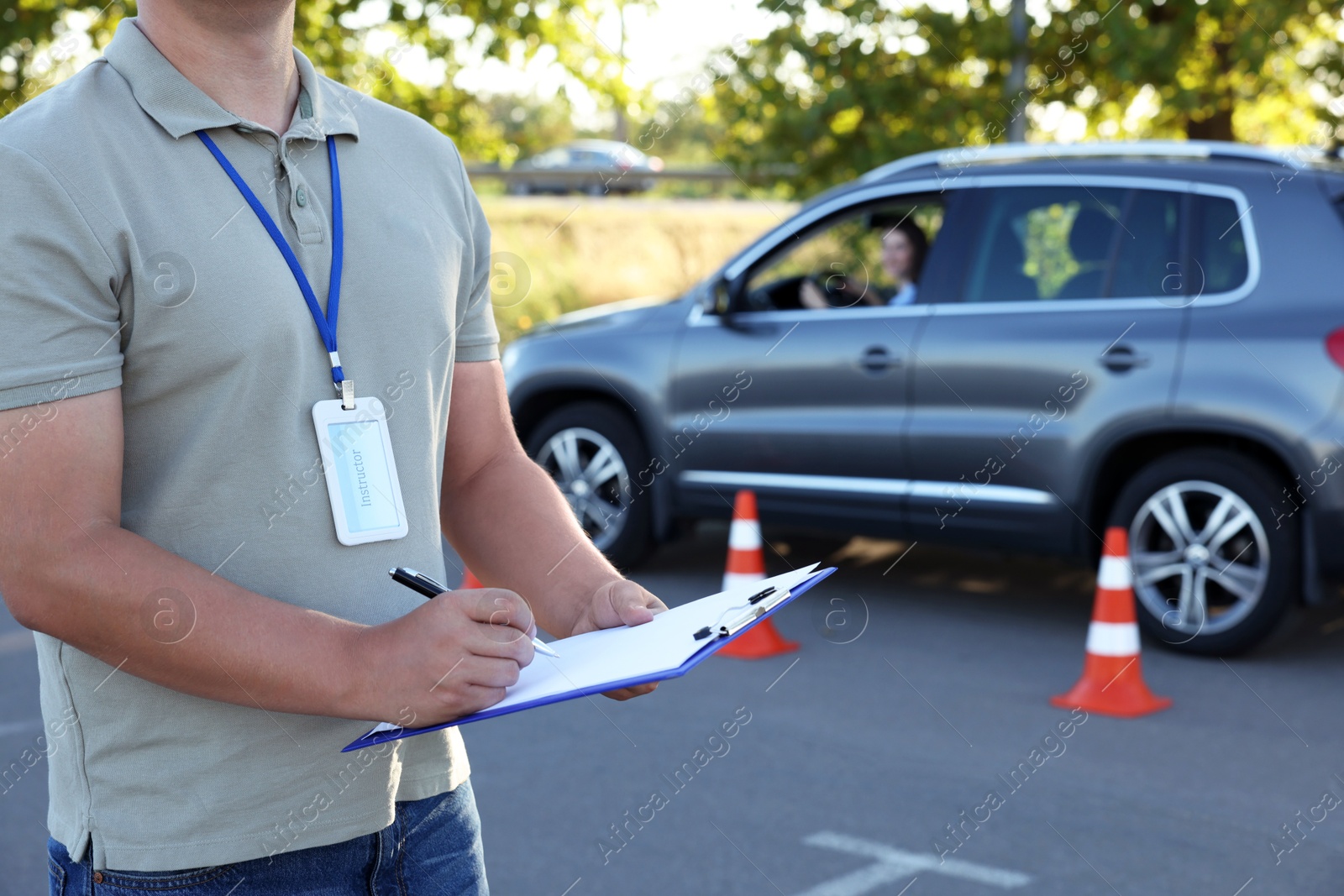 Photo of Examiner with clipboard during exam at driving school test track, closeup