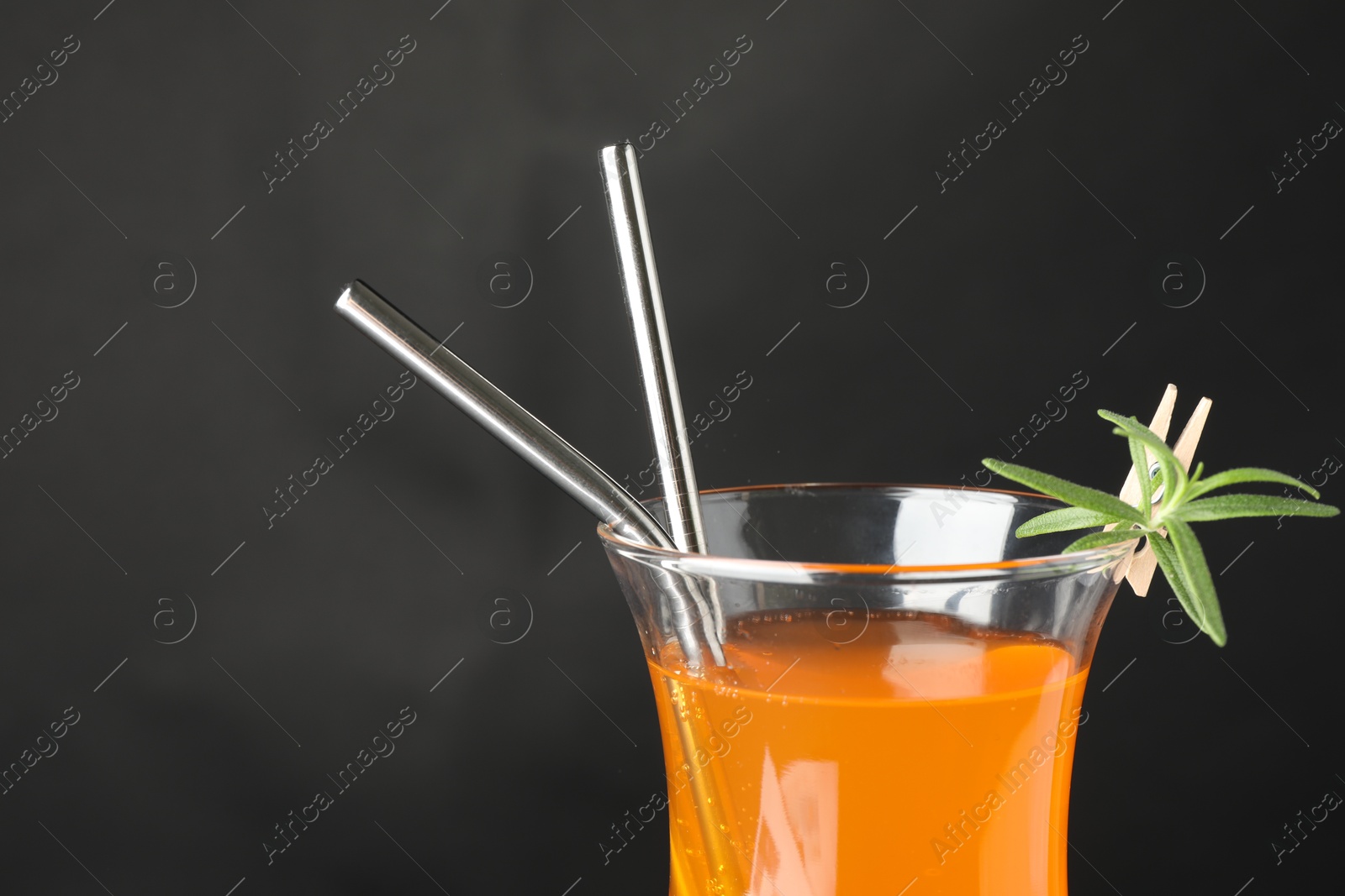 Photo of Tasty refreshing drink with straws in glass on grey background, closeup