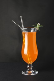 Tasty refreshing drink with straws in glass on grey background