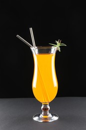 Photo of Tasty refreshing drink with straws in glass on grey table