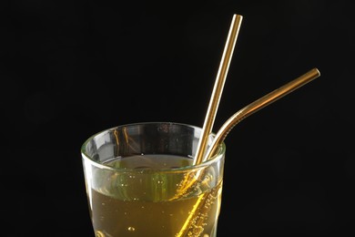 Photo of Tasty refreshing drink with straws in glass on dark background, closeup