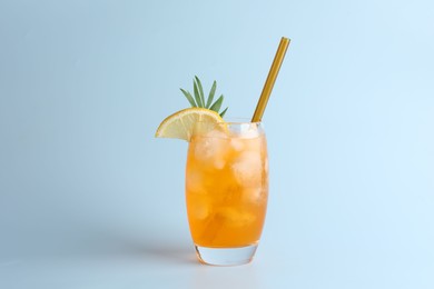 Photo of Tasty refreshing drink with straw in glass on light blue background