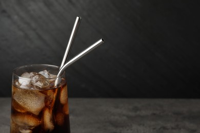 Tasty refreshing drink with straws in glass on table, closeup. Space for text