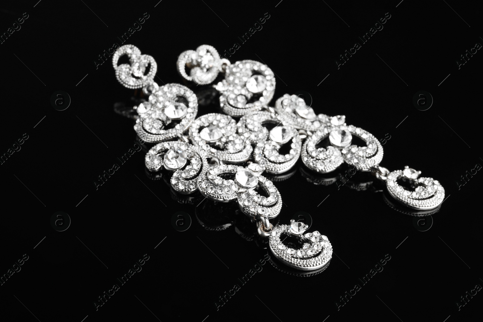 Photo of Beautiful bijouterie. Stylish earrings on black background