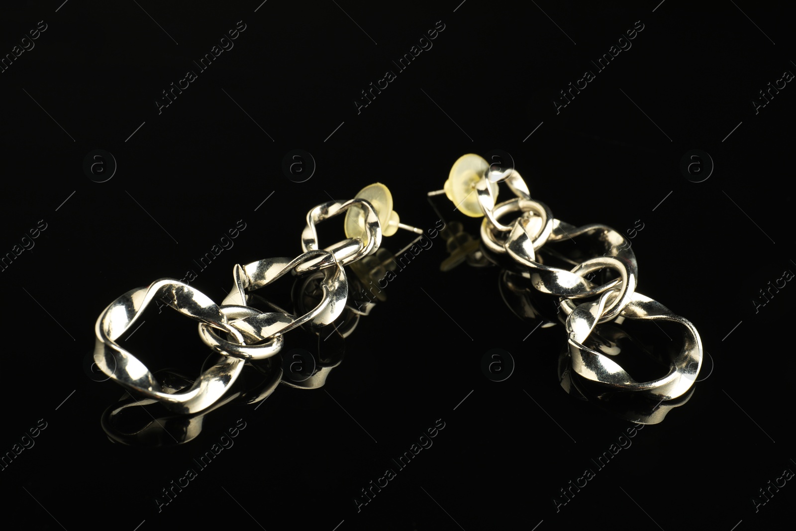 Photo of Beautiful bijouterie. Stylish earrings on black background