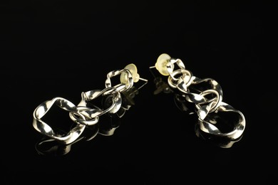 Photo of Beautiful bijouterie. Stylish earrings on black background