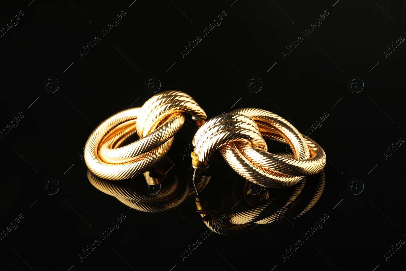 Photo of Beautiful bijouterie. Stylish earrings on black background