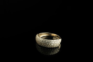 Photo of Beautiful bijouterie. Stylish ring on black background