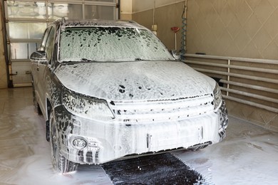 Auto covered with cleaning foam at car wash