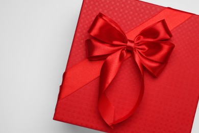 Photo of Gift box with bow on light grey background, top view