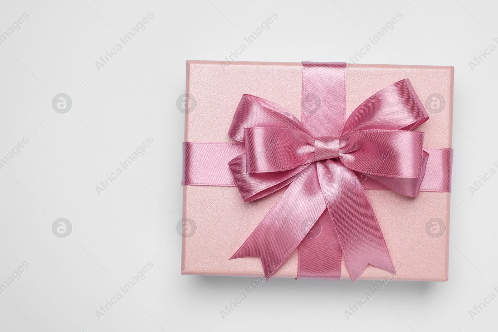 Photo of Gift box with pink bow on light grey background, top view