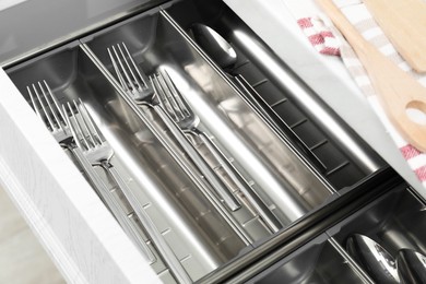 Photo of Box with cutlery in drawer, closeup. Kitchen utensils storage