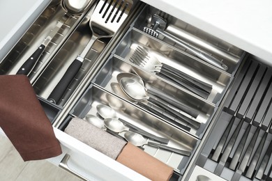 Photo of Box with cutlery in drawer, closeup. Kitchen utensils storage