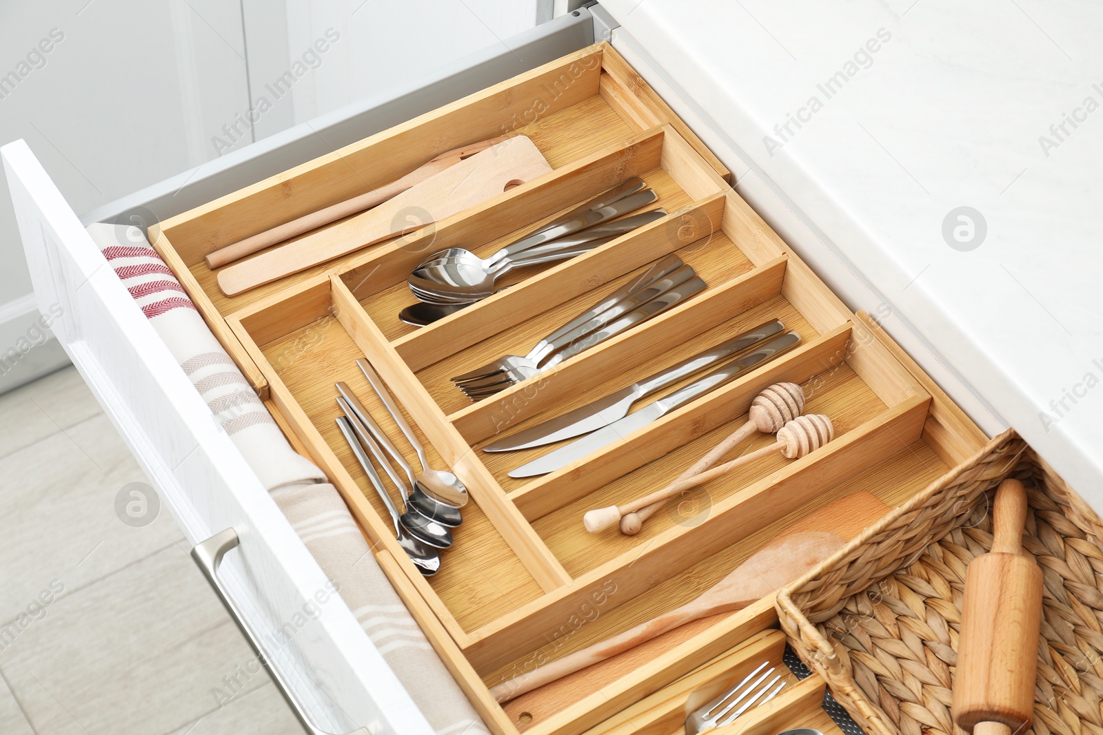 Photo of Box with cutlery in drawer, closeup. Kitchen utensils storage