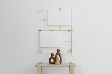 Photo of Mood board with blank paper notes and decorative figures on wooden ladder near white wall