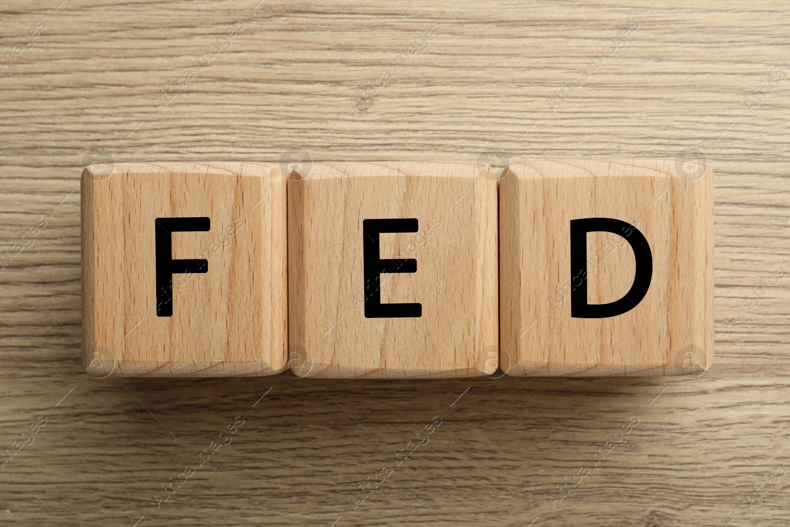 Photo of Cubes with letters Fed (Federal Reserve System) on wooden table, top view