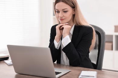 Photo of Banker with laptop working at wooden table in office