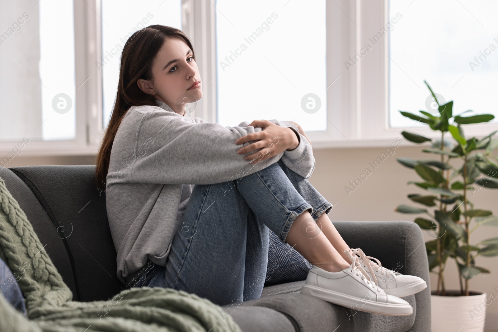 Photo of Loneliness concept. Sad teenage girl on sofa at home