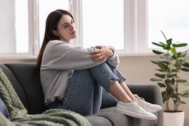 Photo of Loneliness concept. Sad teenage girl on sofa at home