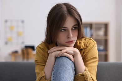 Loneliness concept. Sad teenage girl on sofa at home