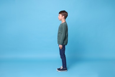 Boy with correct posture on light blue background