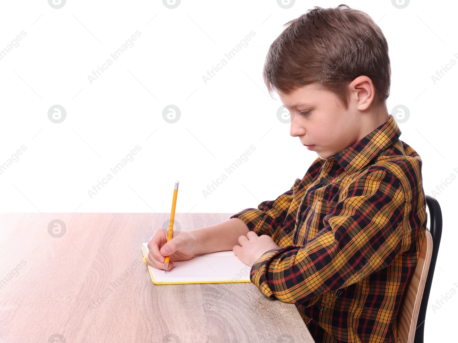 Photo of Boy with correct posture and notebook at wooden desk on white background