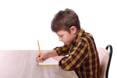 Photo of Boy with incorrect posture and notebook at wooden desk on white background