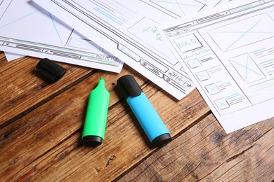 Developing UI design. Sketches of website wireframes and felt pens on wooden table, closeup