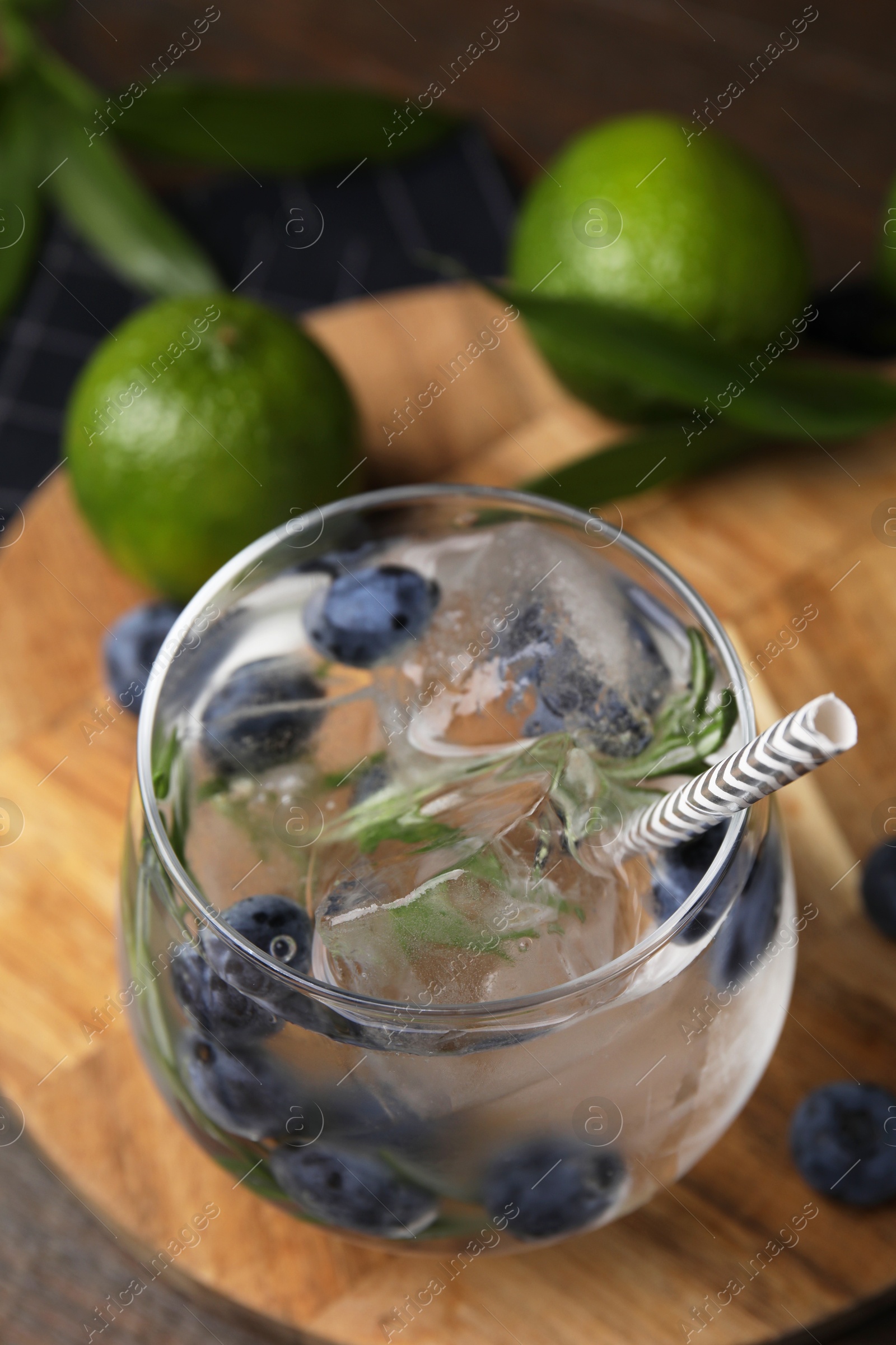 Photo of Refreshing water with blueberries and rosemary in glass on table, closeup