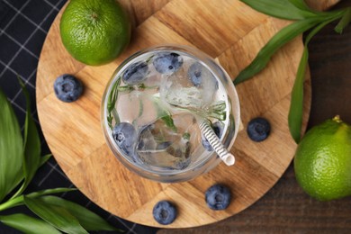 Photo of Refreshing water with blueberries and rosemary in glass on wooden table, flat lay