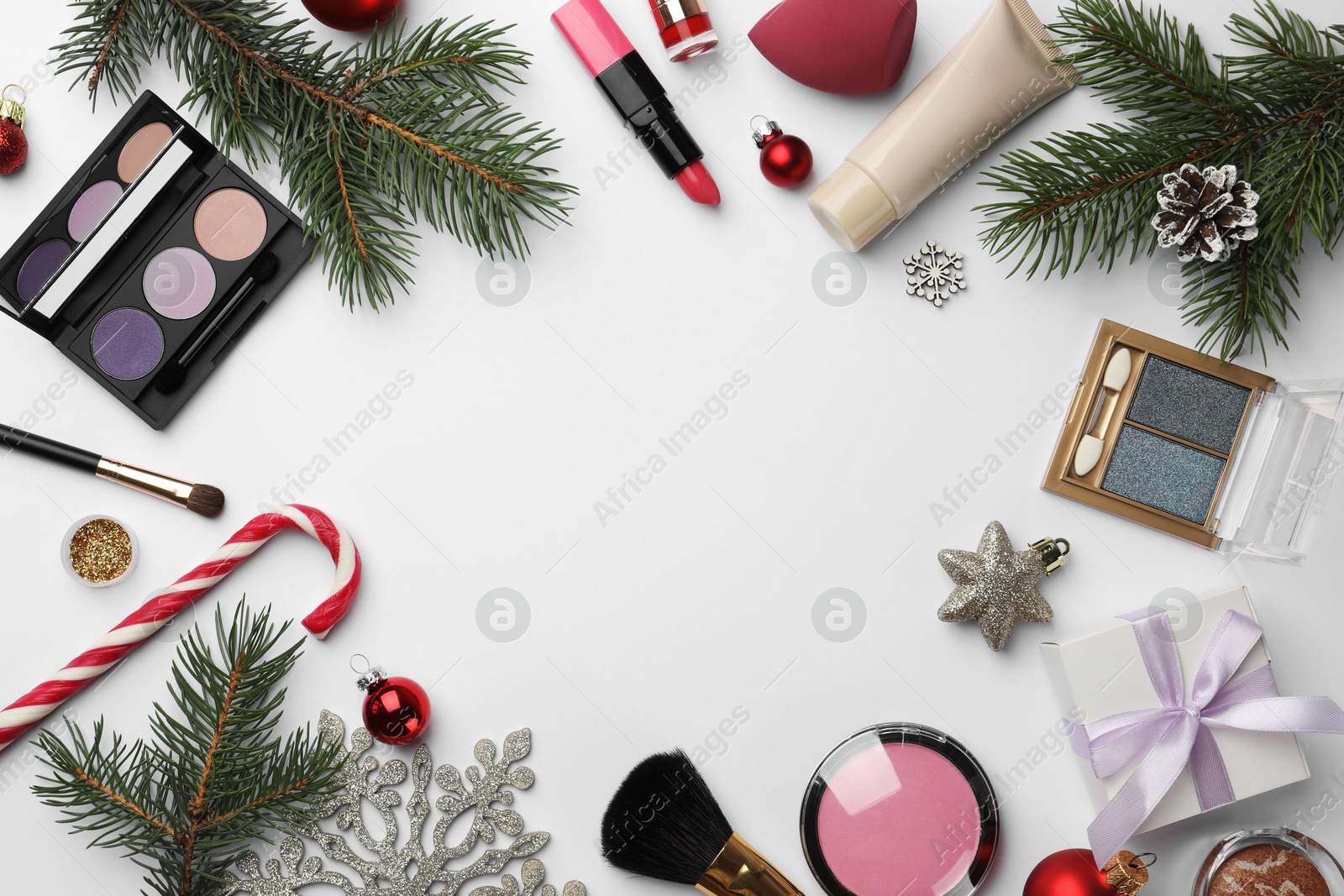 Photo of Frame of different decorative cosmetic products and Christmas decor on white background, flat lay. Space for text