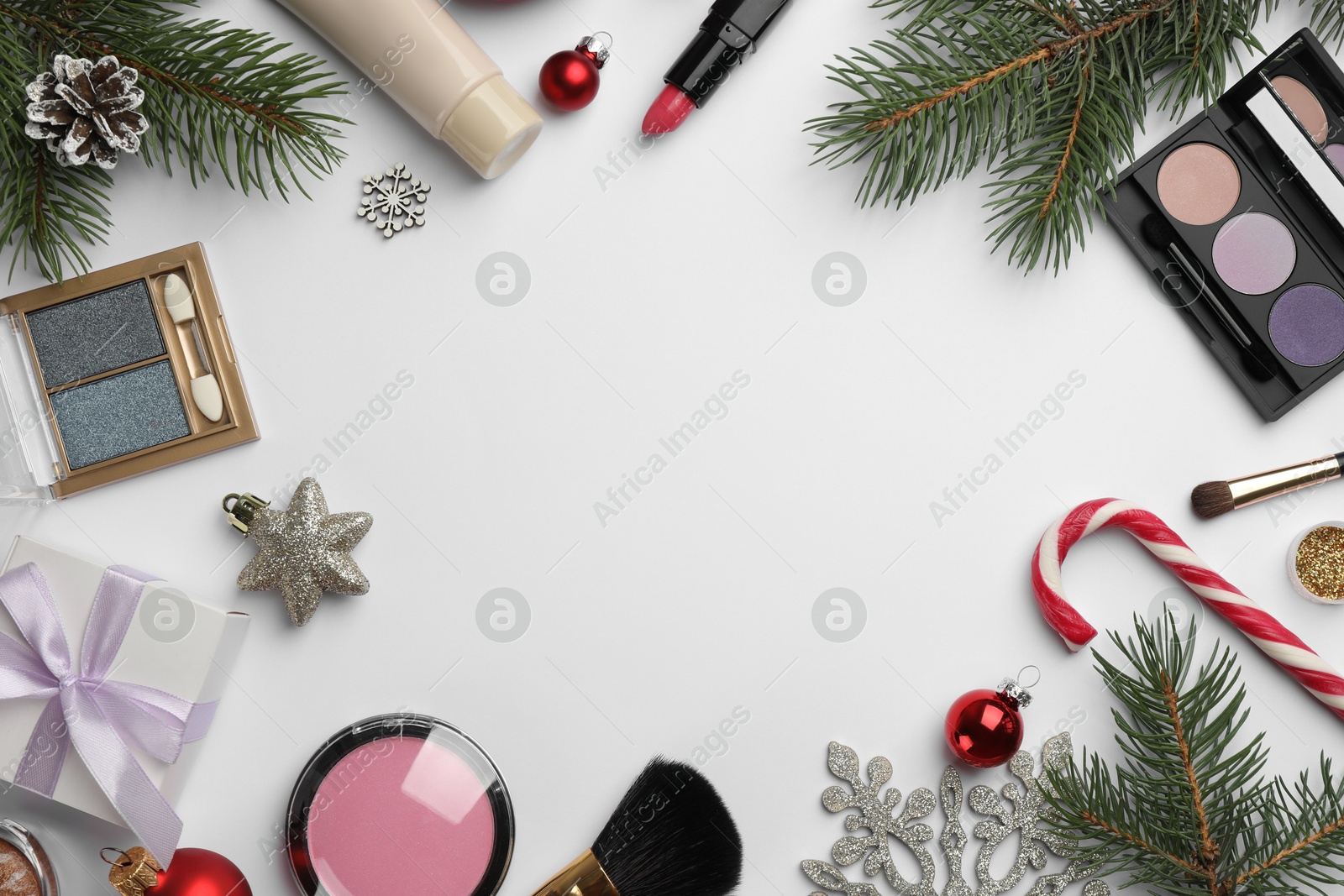 Photo of Frame of different decorative cosmetic products and Christmas decor on white background, flat lay. Space for text