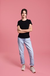 Full length portrait of cute teenage girl on pink background